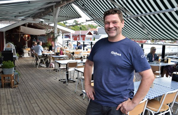 Vert på Sjøbua i Sponvika ønsker velkommen på den solfylte terrassen med utsikt over Ringdalsfjorden – populær uteservering nær Halden